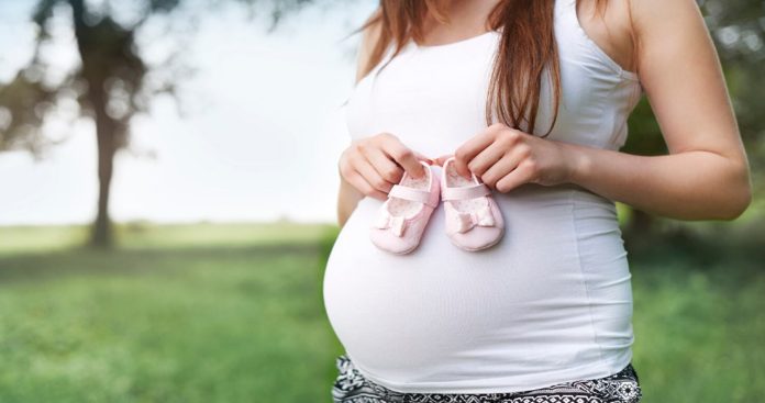Femeie insarcinata depunand certificatul medical de maternitate si lauzie la biroul de resurse umane